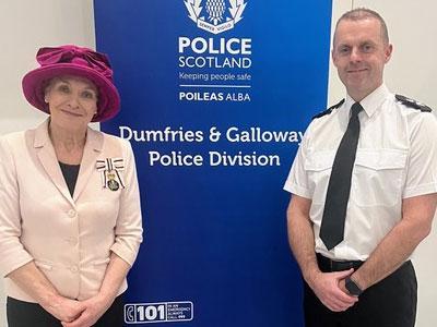 Fiona Armstrong, Lord-Lieutenant of Dumfries stands with Chief Superintendent Steven Meikle in front a banner with the Police Scotland logo on.